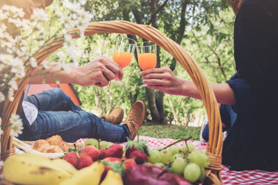 Midsection of couple toasting juice glasses