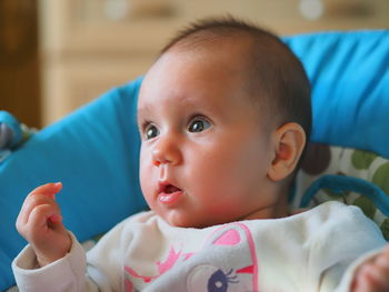 Close-up portrait of cute baby lying on bed