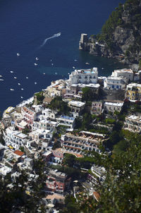 Residential district on mountain by sea against clear sky