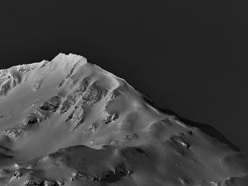 Low angle view of snowcapped mountain against clear sky