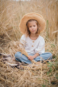 Portrait of young woman wearing hat standing in nest