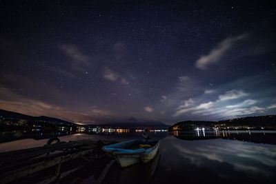 Scenic view of illuminated lake against sky at night