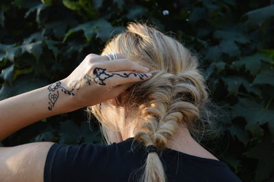 Rear view of woman touching her braided hair