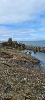 Rocks on beach against sky