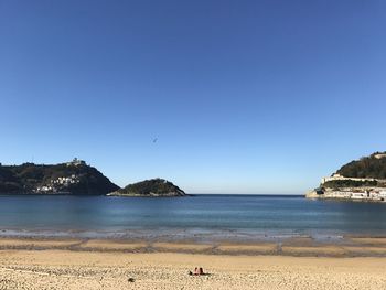 Scenic view of beach against clear blue sky