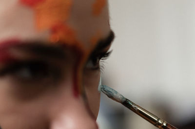 Close-up of young woman applying face paint