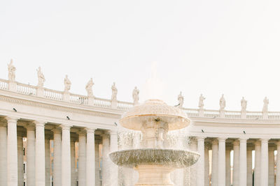 Fountain in front of building against clear sky