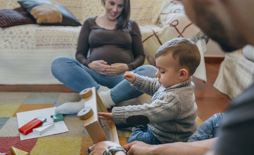 Parents and son playing with toys at home