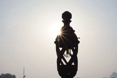 Low angle view of silhouette statue against clear sky