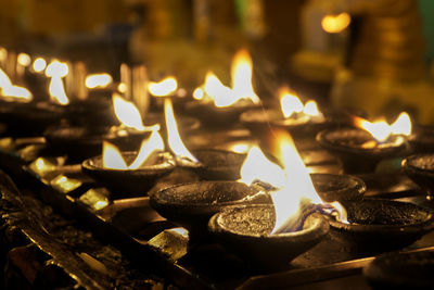 Close-up of oil lanterns burning in pagoda