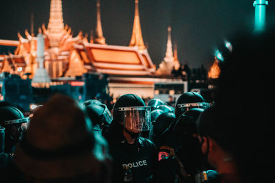 Rear view of people at illuminated city