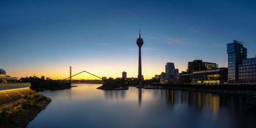 Sunset over river with buildings in background