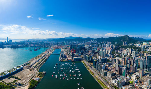 High angle view of city by sea and buildings against sky