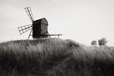 Traditional windmill on field against sky