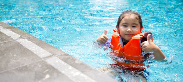 Portrait of smiling boy swimming in pool