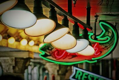 Close-up of illuminated electric lamp hanging in restaurant