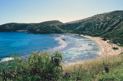 Scenic view of sea and mountains against clear sky