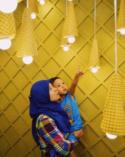 Mother and son looking at illuminated pendant lights