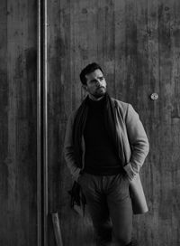 Young man standing against wall