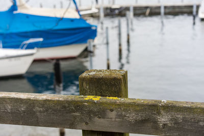 Close-up of wooden post on pier against lake