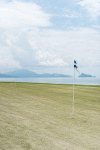 Scenic view of golf course against sky