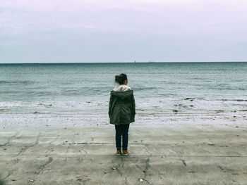 Rear view of man standing on beach