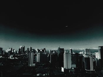 Silhouette cityscape against sky