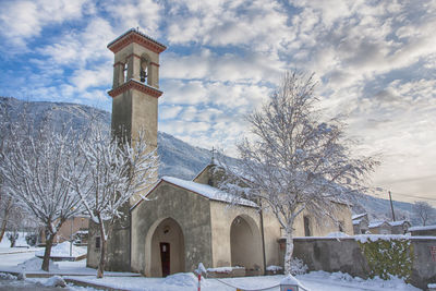 Low angle view of church against cloudy sky during winter