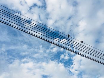 Low angle view of crane against cloudy sky