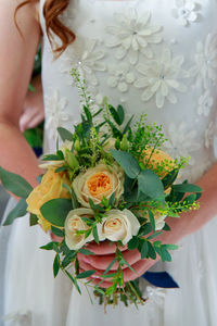 Midsection of woman holding flower bouquet