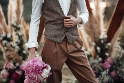 Midsection of man holding flowering plants