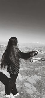 Rear view of woman on shore against sky