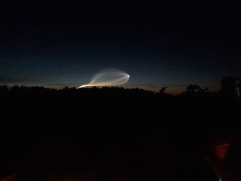 Silhouette landscape against sky at night