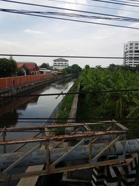 Bridge over river in city against sky