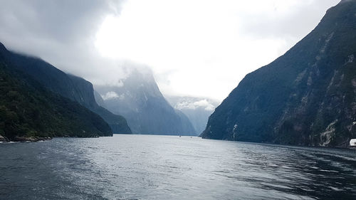 Scenic view of lake by mountains against sky