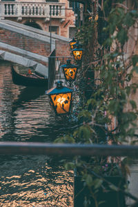 Illuminated lighting equipment on brick wall near water