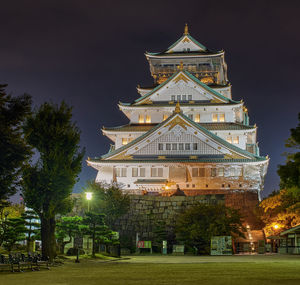 Low angle view of illuminated building against sky at night