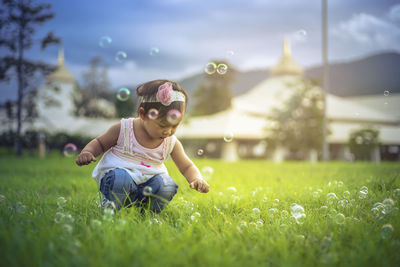 Full length of girl sitting on field