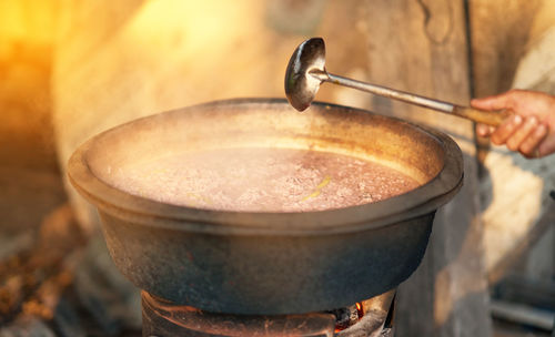 Close-up of hand holding ladle cook soup