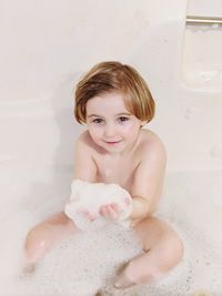 Cute little boy taking a bubble bath