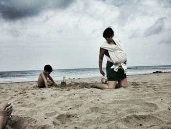 Scenic view of beach against cloudy sky