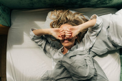 High angle view of woman lying on bed at home