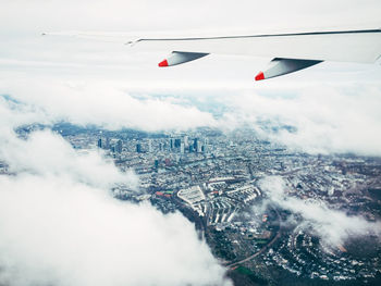 Cropped image of airplane flying over cityscape