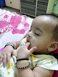 High angle view of cute baby girl relaxing on bed at home