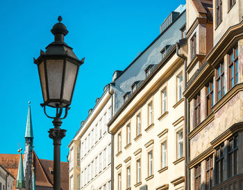 Low angle view of lamp post against buildings in city