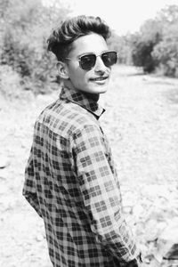 Portrait of young man wearing sunglasses standing outdoors