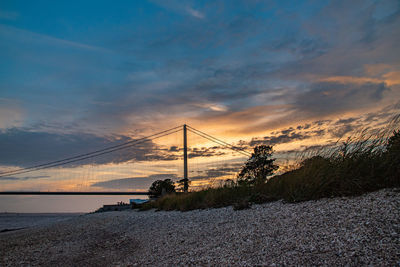 Scenic view of suspension bridge against sky during sunset