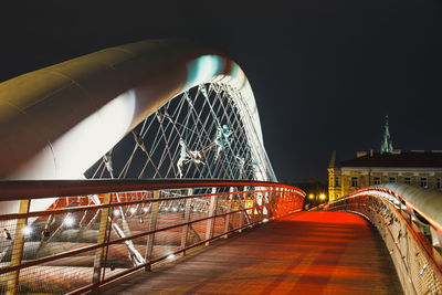 Illuminated bridge against sky at night