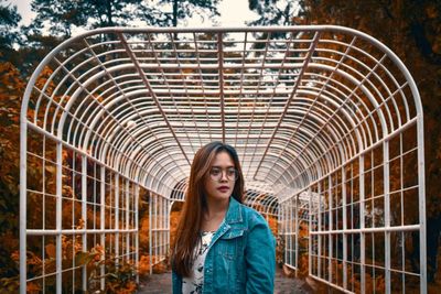 Beautiful young woman against covered walkway