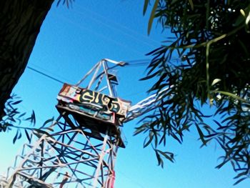 Low angle view of road sign against clear blue sky